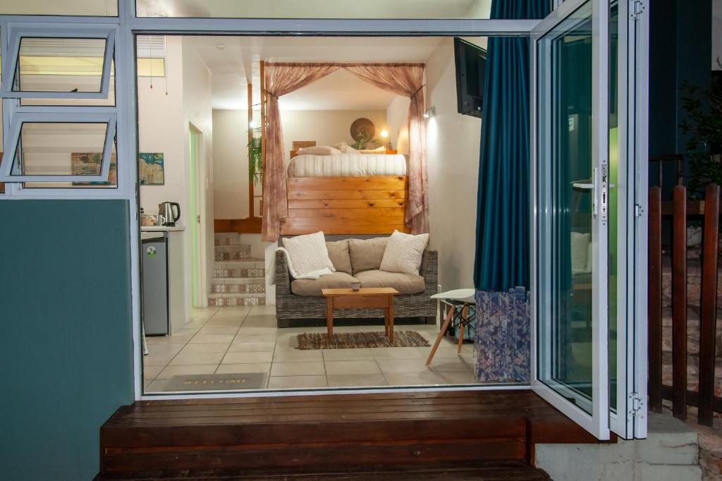 莫塞尔湾Accommodation Mossel Bay Garden Route的一间卧室配有一张床和一个沙发