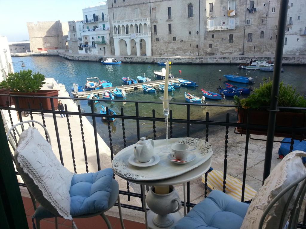 莫诺波利Palazzo Venezia - Luxury holiday rooms的阳台配有桌椅,享有海港的景致。