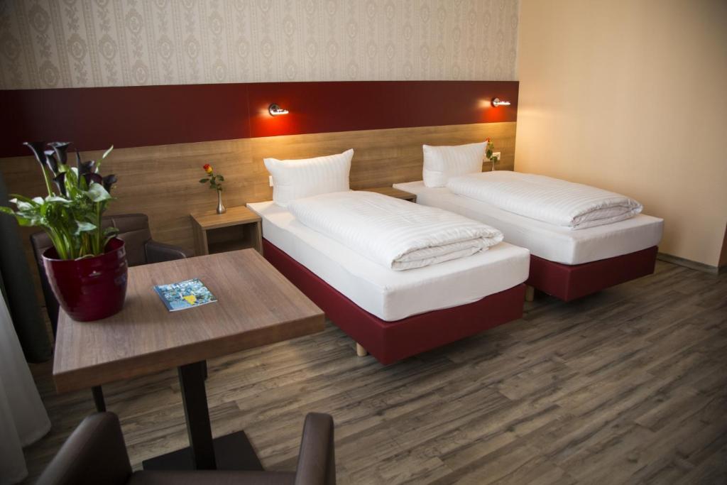 汉诺威城市全景酒店的酒店客房设有两张床和一张桌子。