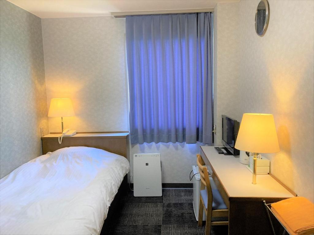 阿南Bayside Hotel Ryugu / Vacation STAY 63706的酒店客房配有一张床和一张带电脑的书桌