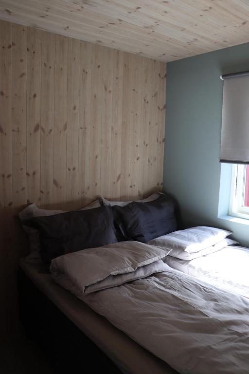 莱克内斯Visit Mortsund, Lofoten的木墙客房的一张床位