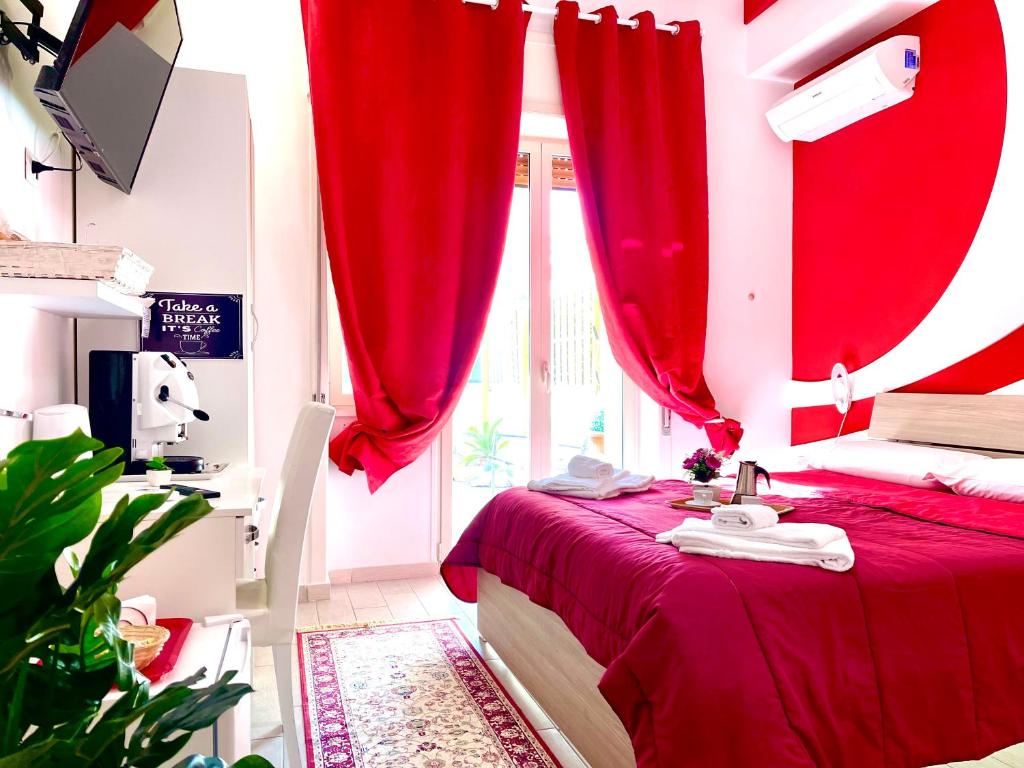 那不勒斯Terrazza Garibaldi的红色卧室配有红色窗帘的床