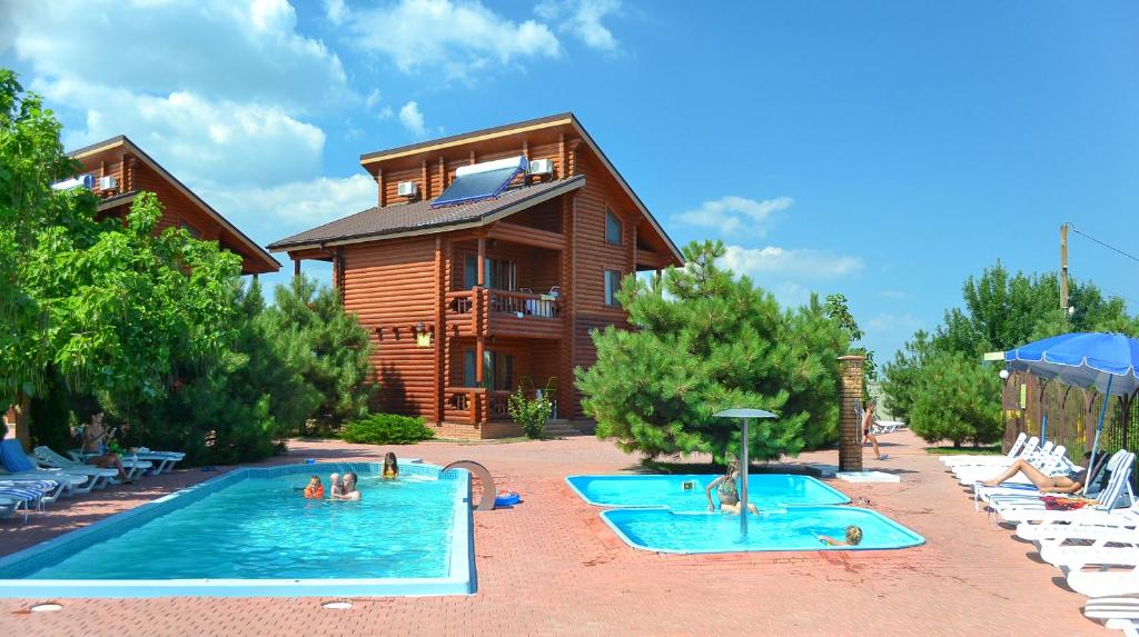 格里比夫卡Парк-отель Коттеджи Меркурий的度假村设有2个游泳池,其中有人