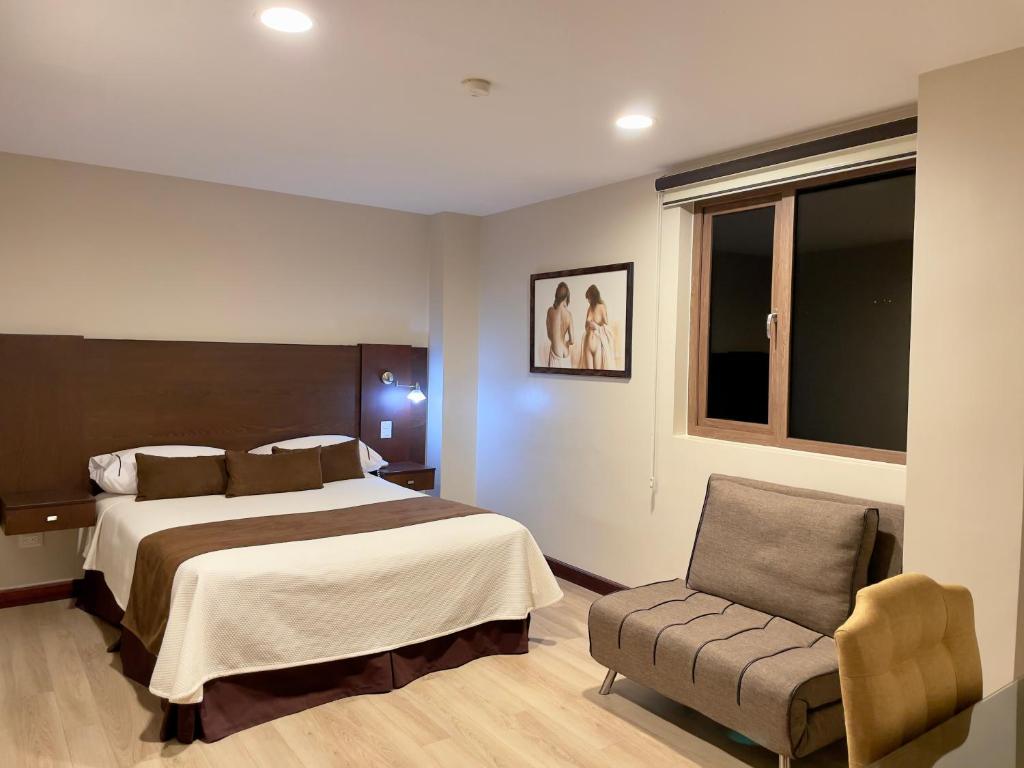 昆卡Hotel Patrimonio的配有一张床和一把椅子的酒店客房