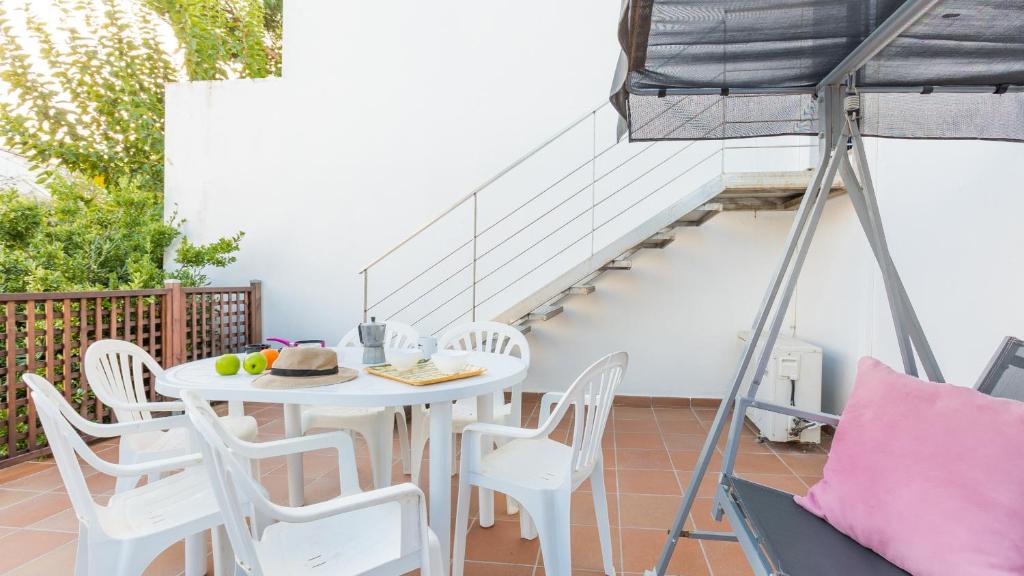 卡莱利亚德帕拉弗鲁赫尔1Solive - Calella de Palafrugell的阳台上设有白色的桌椅,可经楼梯抵达