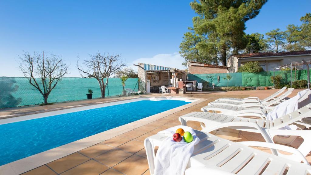 蒙特巴巴特2Alo - Lloret de Mar的一个带白色躺椅的游泳池和一个游泳池