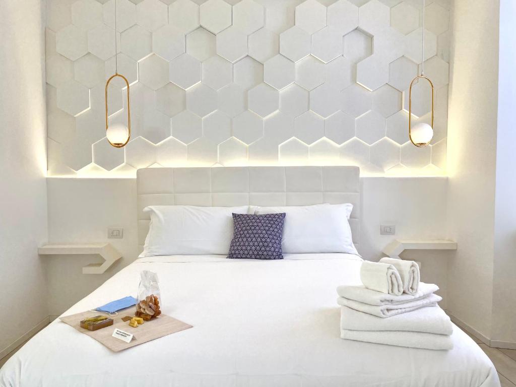 科莫Mariarosa Suites的卧室配有白色床、两条毛巾和灯