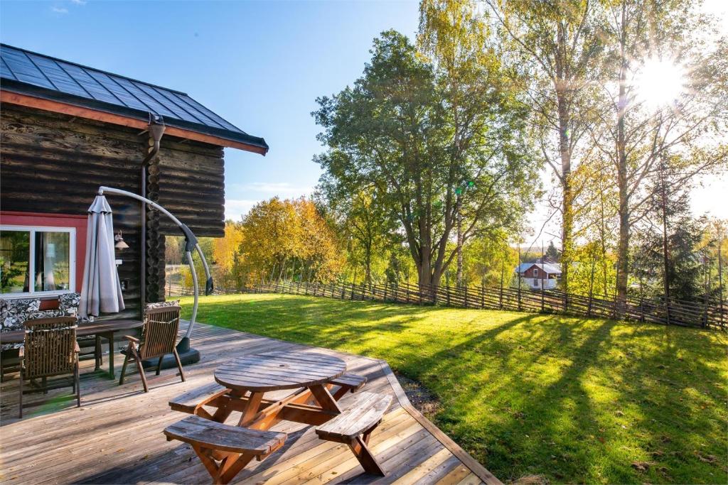 BergsjöLuxurious Log House - Gränsfors 354的后院设有木甲板和野餐桌