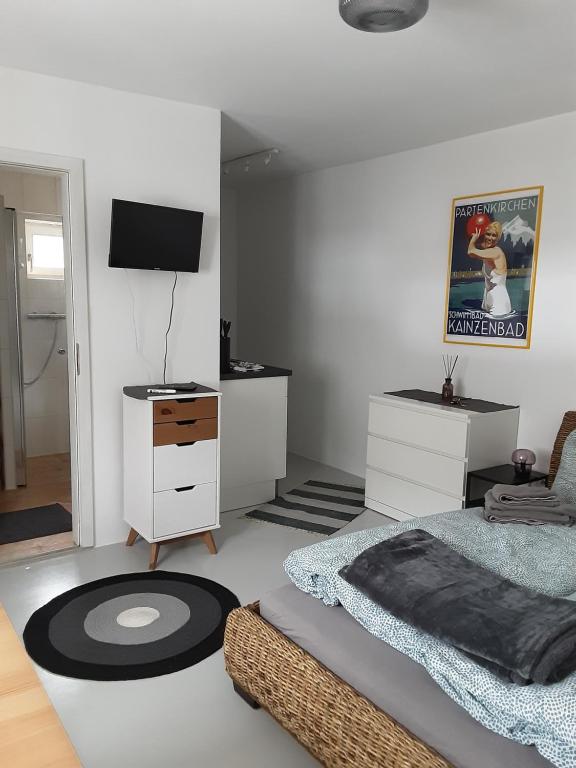加尔米施-帕滕基兴Appartement im Hasental的一间卧室配有一张床、梳妆台和电视。