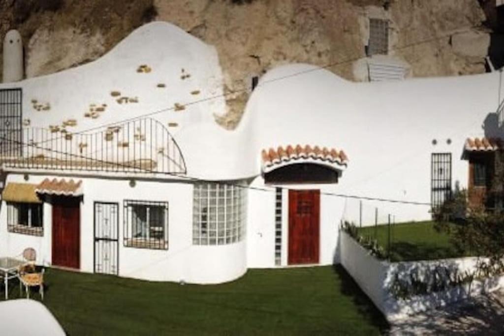 莫纳奇尔Las Cuevas de Monachil的山前有红色门的白色房子