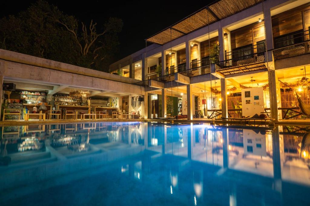 巴卡拉尔Hotel Makaabá Eco-Boutique的一座游泳池,在晚上在建筑物前