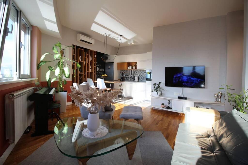 斯科普里Kristina's Cozy Designer Apartment的客厅配有玻璃桌和电视