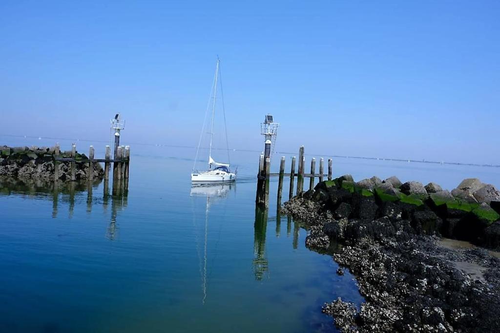 布勒伊尼瑟IJsvogel Apartment, Duplex Family Home 4-bed located on the largest saltwater lake的船停靠在水面上的码头