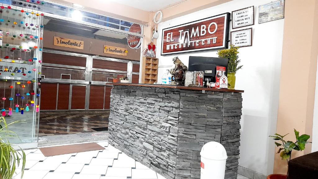 马丘比丘El Tambo Machupicchu的一间位于餐厅内的酒吧,餐厅设有石墙