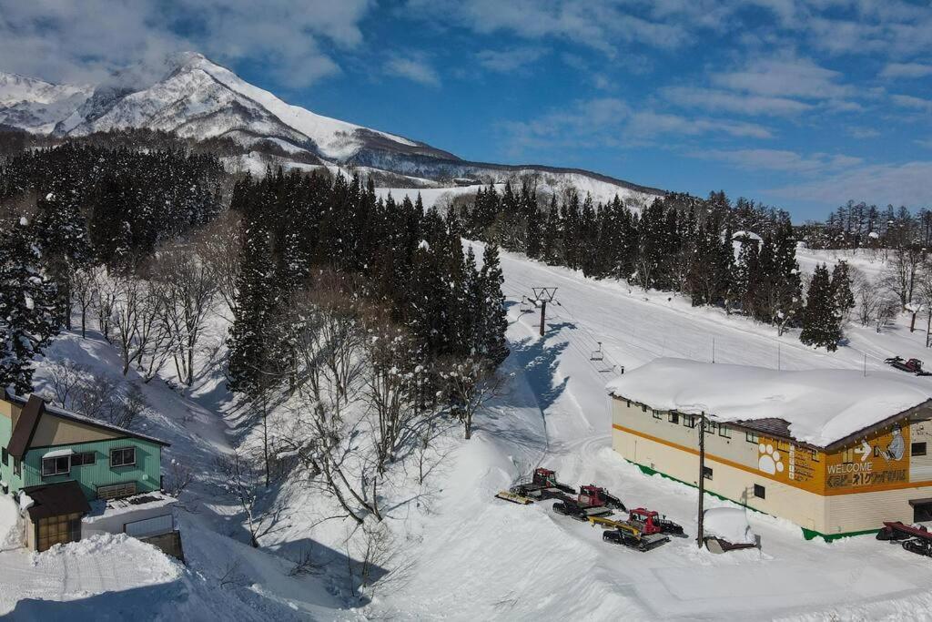 AkakuraSki In Ski Out Myoko. Luxury Chalet sleeps 12的山旁的雪地建筑