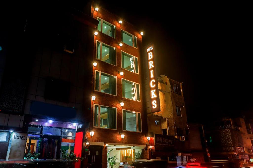 新德里Hotel Bricks, Karol Bagh, New Delhi的建筑的侧面有 ⁇ 虹灯标志