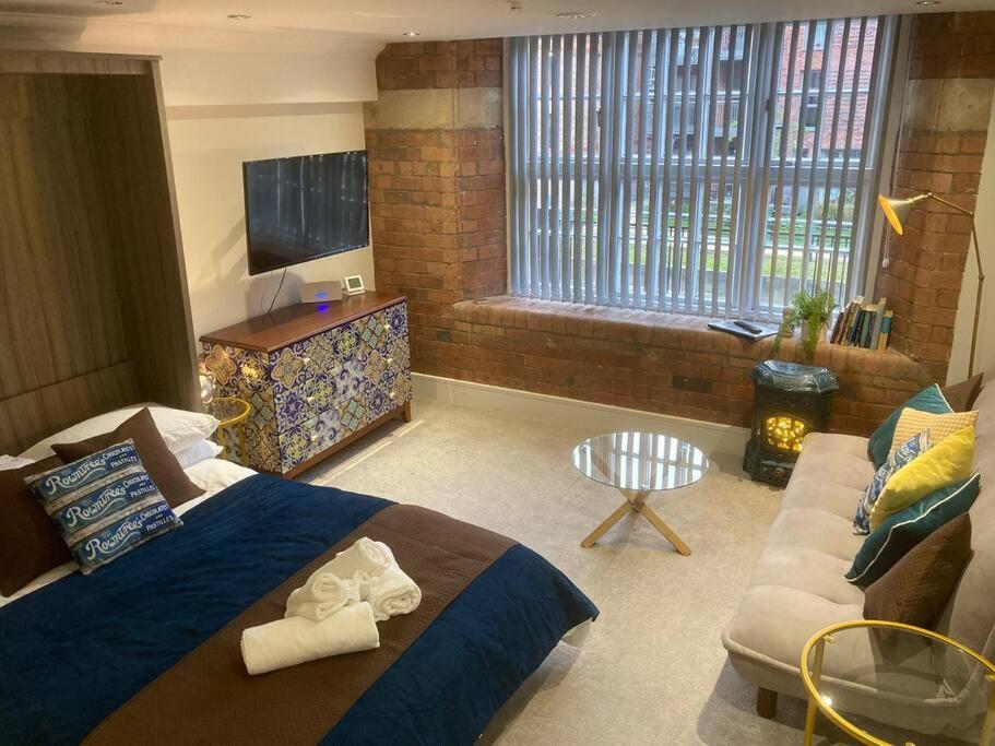 约克48 Cocoa Suites, York City Centre的一间卧室配有一张床、一张沙发和一台电视