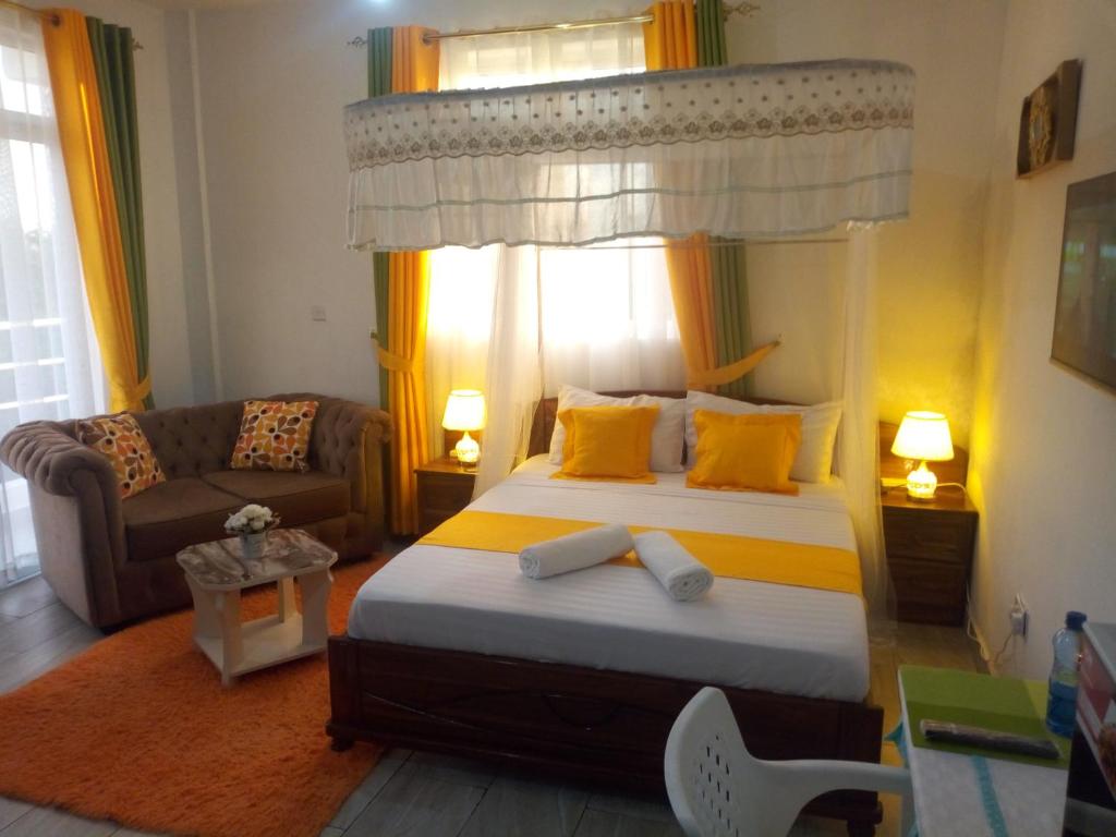 蒙巴萨Pride Studio Mtwapa的一间卧室配有一张床和一个沙发
