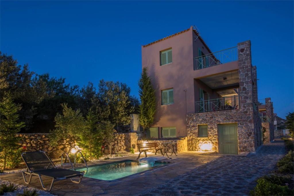 爱琴娜岛Villa Carmina的夜间带游泳池的别墅