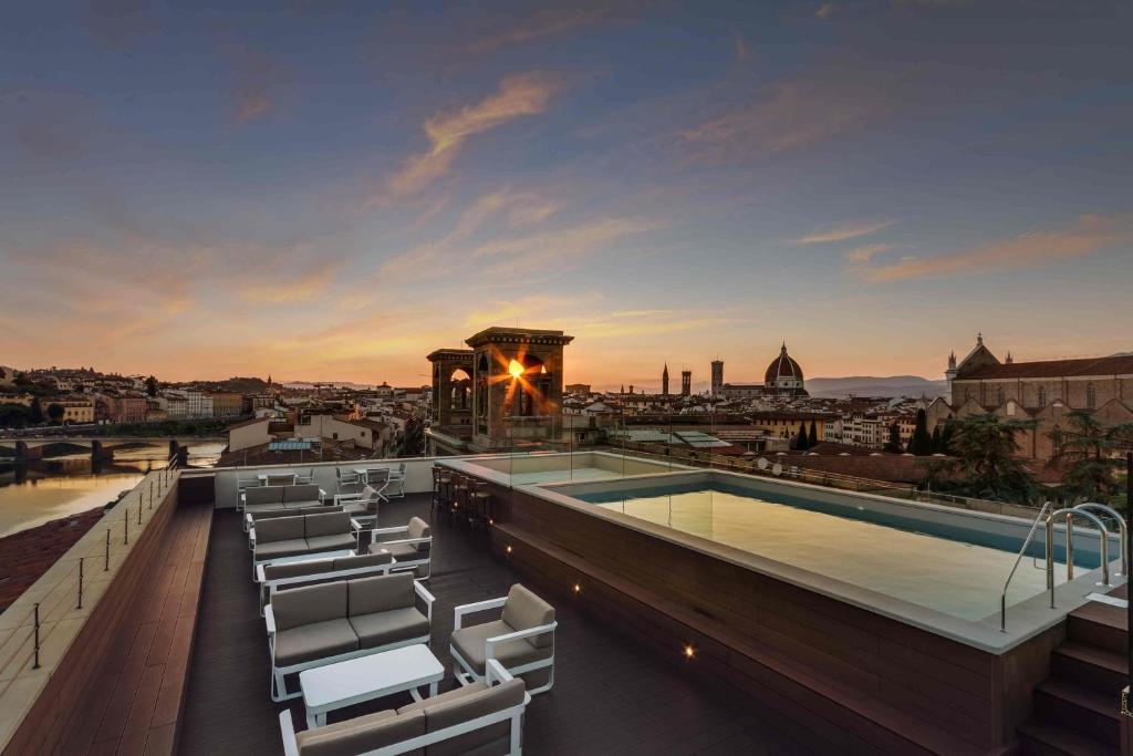 佛罗伦萨露可西广场酒店的一座带椅子的建筑屋顶上的游泳池