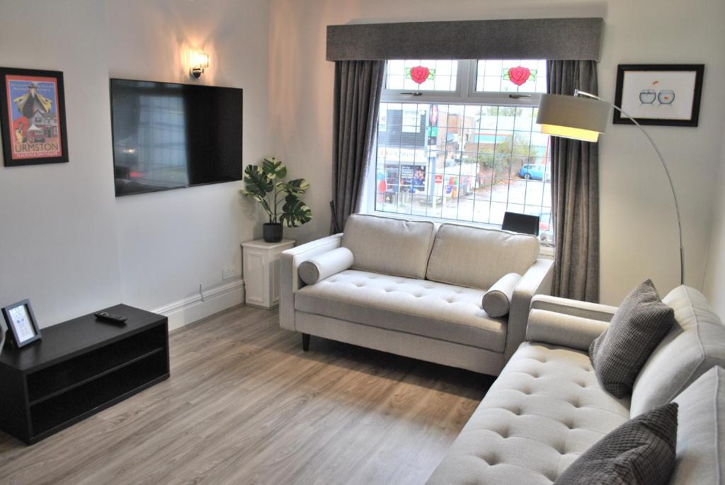 UrmstonTrafford Terrace Davyhulme的客厅配有白色沙发和窗户