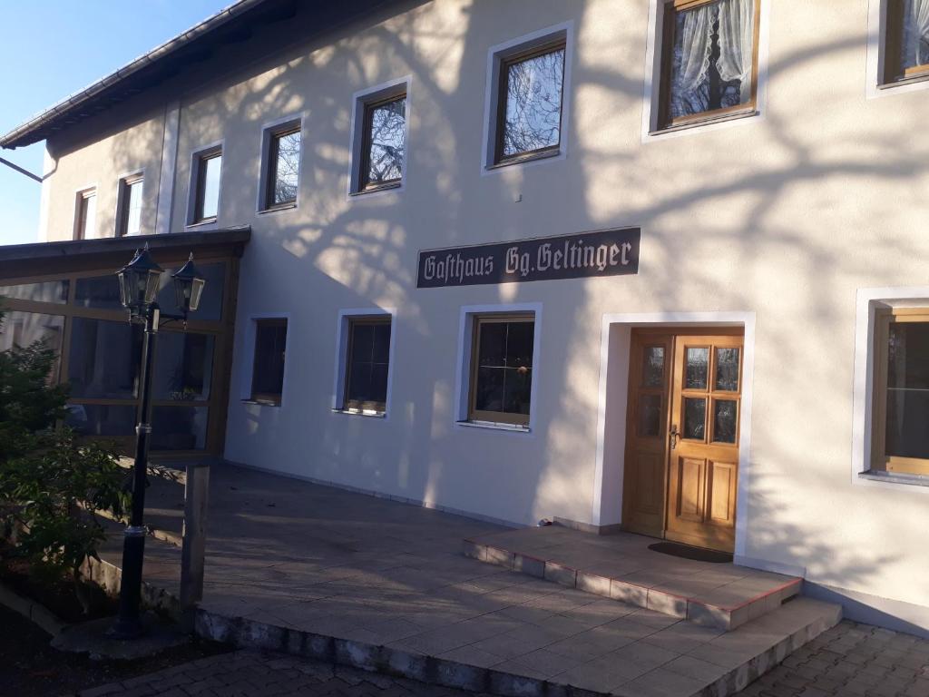 AdlkofenLandgasthof Geltinger的建筑物,带有读取建筑物入口的标志