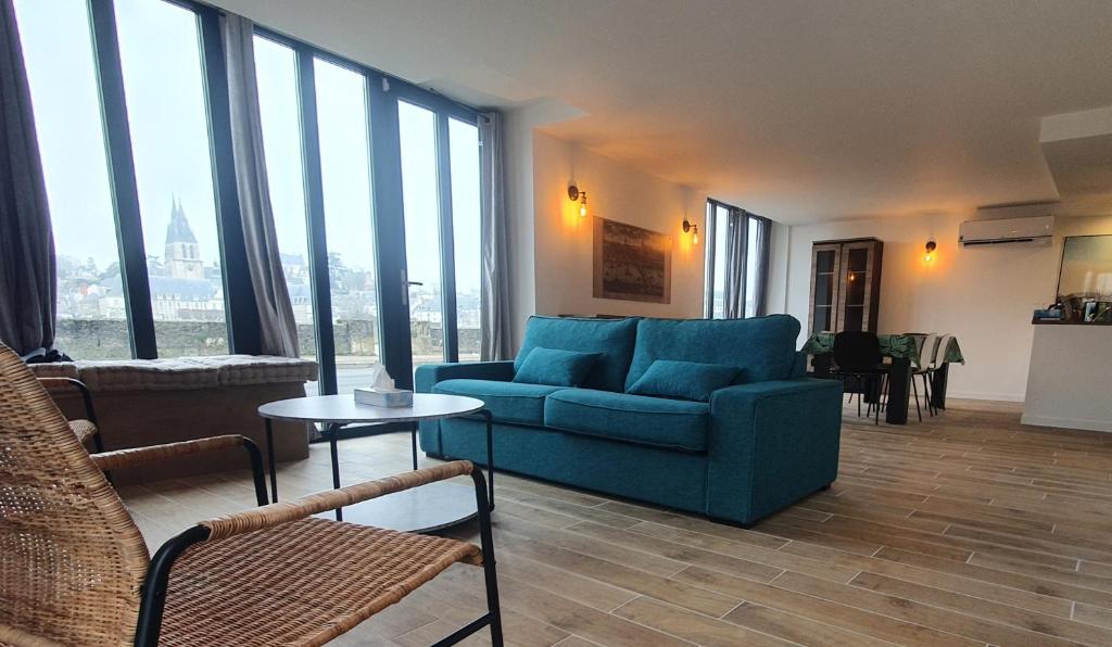 布鲁瓦"Gîte Le Relais Viennois" vue sur Loire & linge inclus的客厅设有蓝色的沙发和大窗户