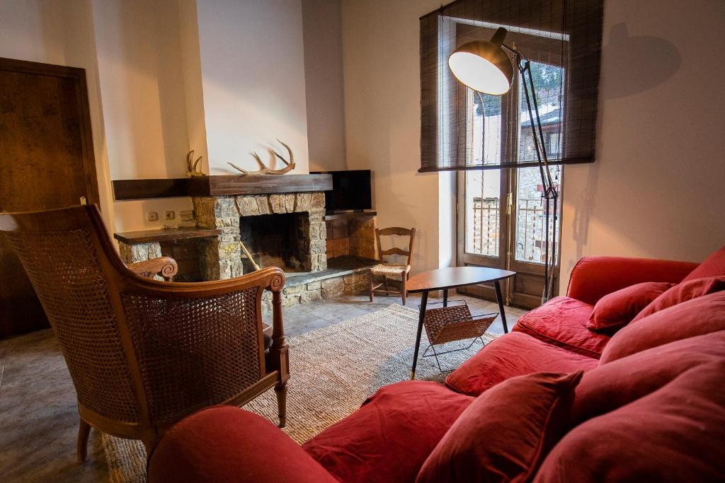 PratsJAT MOUNTAIN HOUSES - Casa Jarca 2on pis Àtic, a 1km de Canillo的客厅设有红色的沙发和壁炉