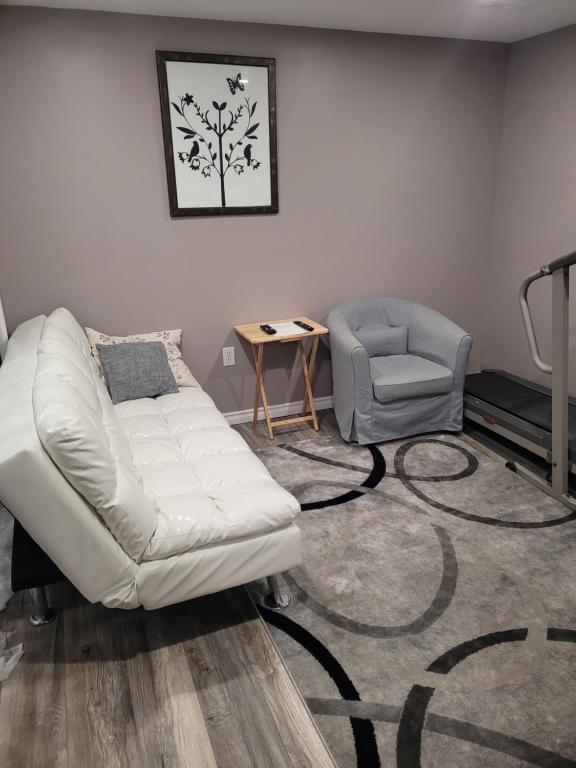 巴里Adorable Studio Basement Suite in South Barrie的客厅配有白色的沙发和椅子