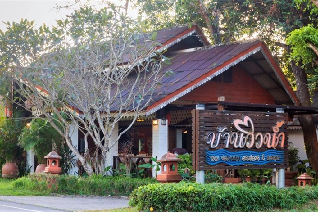 Bān Tha Pu Deang班维南野营度假村的前面有标志的房子
