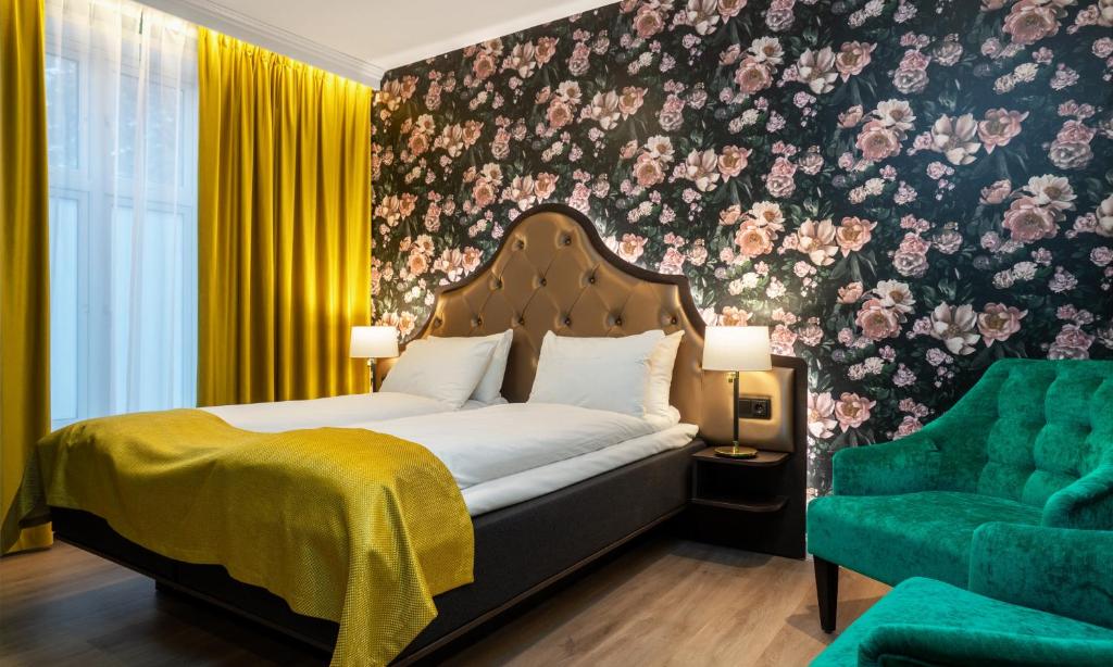 希恩敦豪耶斯酒店的一间卧室配有一张床和一把绿色椅子