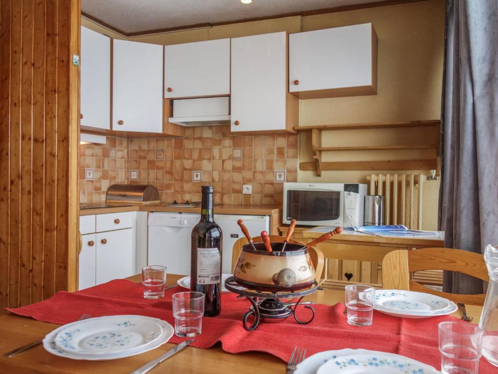 蒂涅Apartment Les Pistes-2 by Interhome的厨房配有带1瓶葡萄酒的桌子