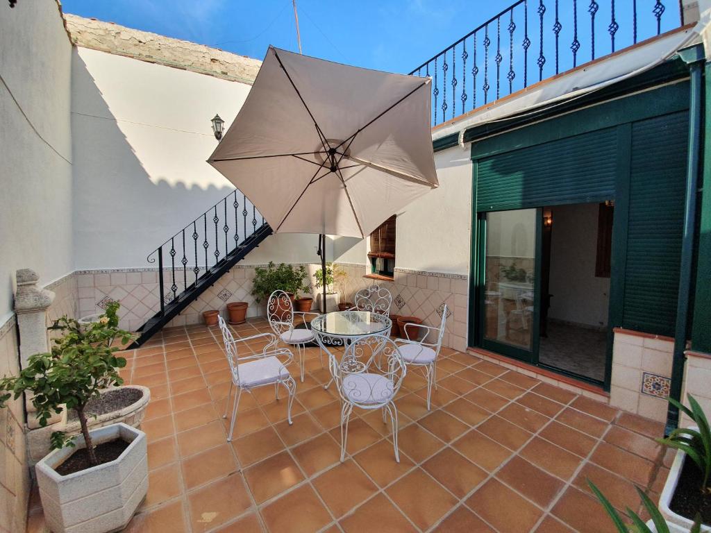 钦琼Casa La Plazuelilla的庭院配有桌椅和遮阳伞。