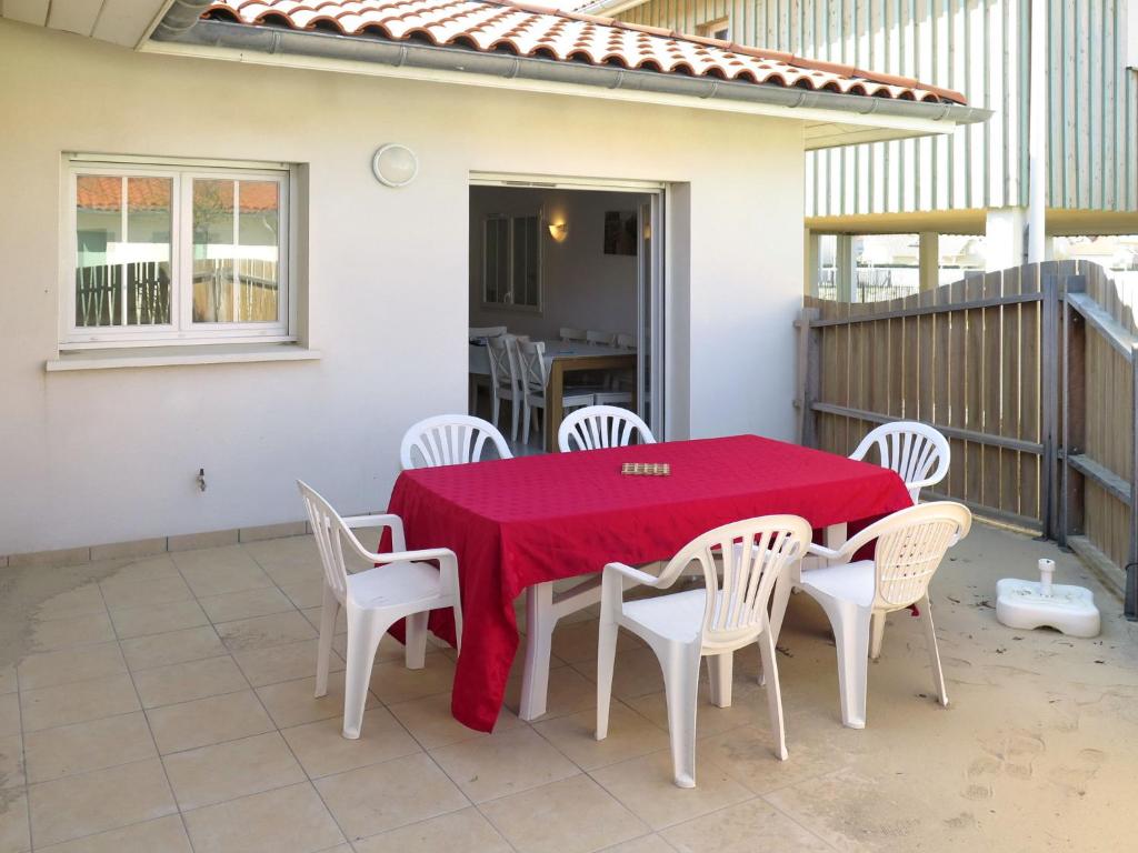 比斯卡罗斯海滩Holiday Home Résidence Plage Océane - BPL340 by Interhome的庭院里配有桌椅和红色桌布