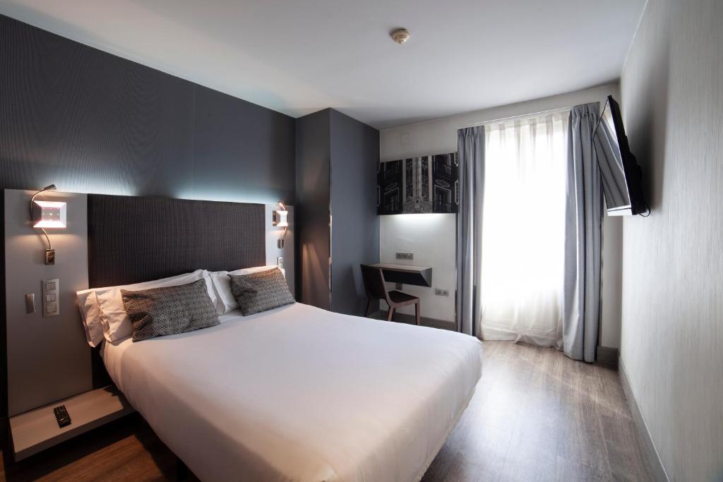 马德里小西班牙广场宫殿酒店的卧室设有一张白色大床和一扇窗户。