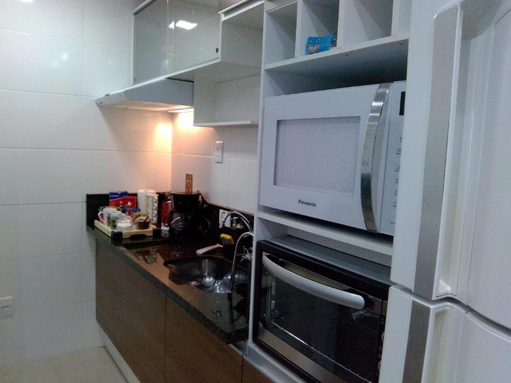 莫日-达斯克鲁济斯Apartamento completo A42 Flat Centro的厨房配有微波炉和水槽。