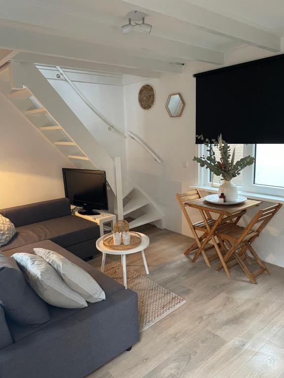 滨海卡特韦克Vakantiehuis Katwijk Andreasplein的客厅配有沙发和桌子