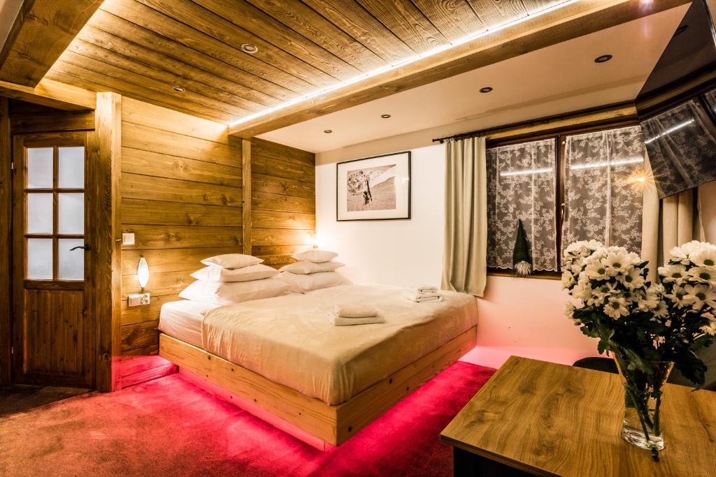 扎科帕内Apartamenty Szymaszkowa的一间卧室设有一张大床和木制天花板