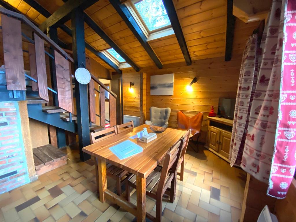 拉布雷斯LE FLOCON 1 Appartement avec terrasse的一间带木桌和椅子的用餐室