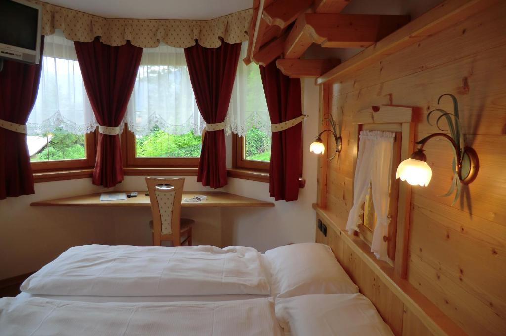 博曾安古Garnì Costa Verde的卧室在窗户前配有一张床