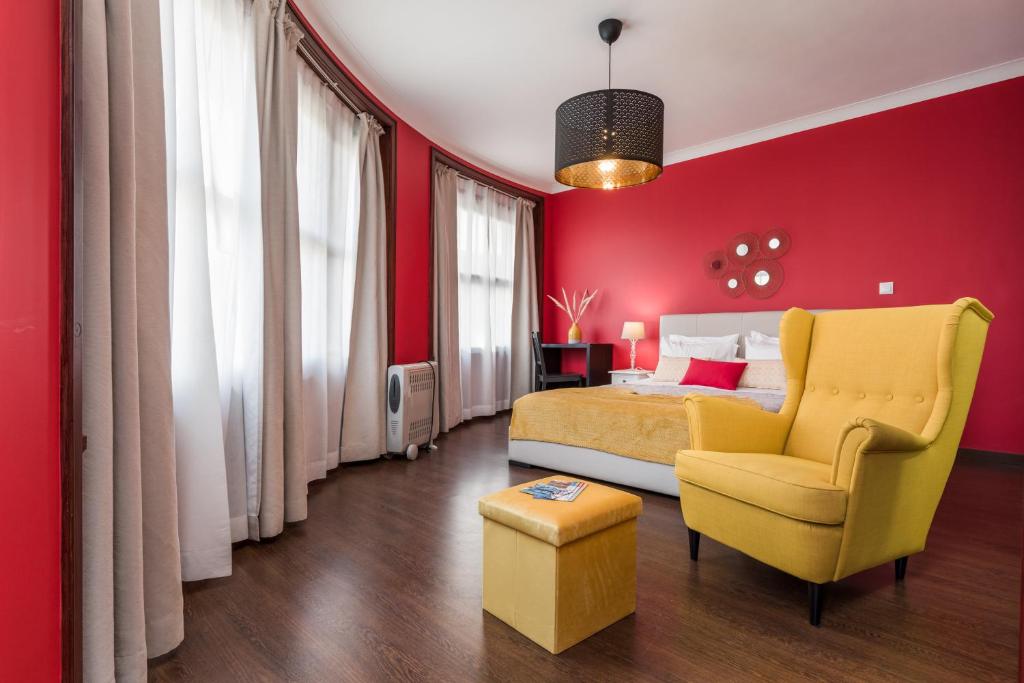 波尔图Oporto Santa Catarina Residence的一间卧室设有红色的墙壁、一张黄色的床和椅子