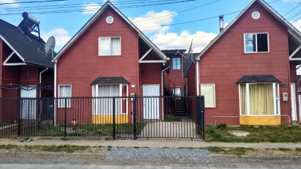 比亚里卡Casa Parque Villarrica, Los Albatros的一排带黑色栅栏的红色房屋