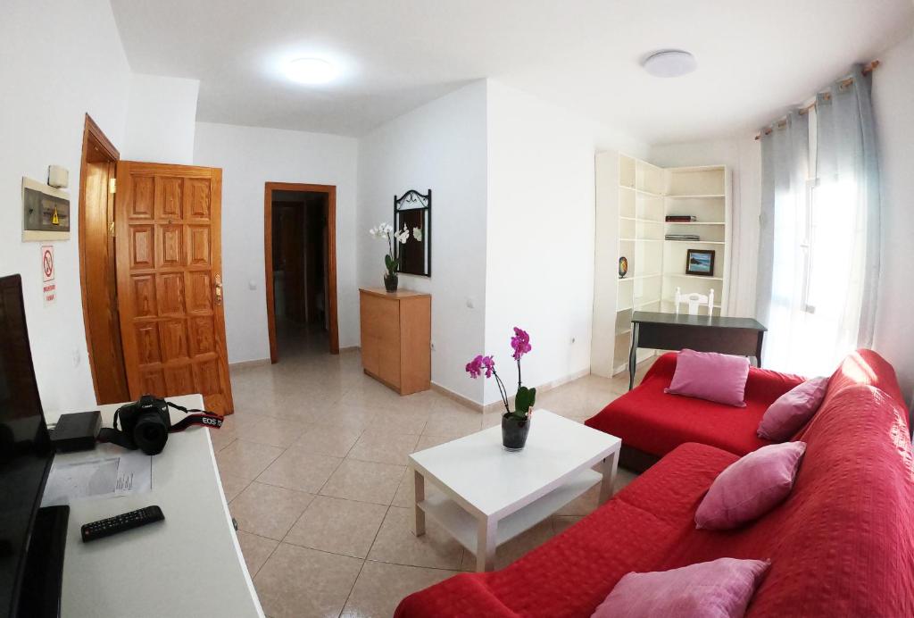 大塔拉哈尔Apartamento junto el mar的客厅配有红色的沙发和桌子