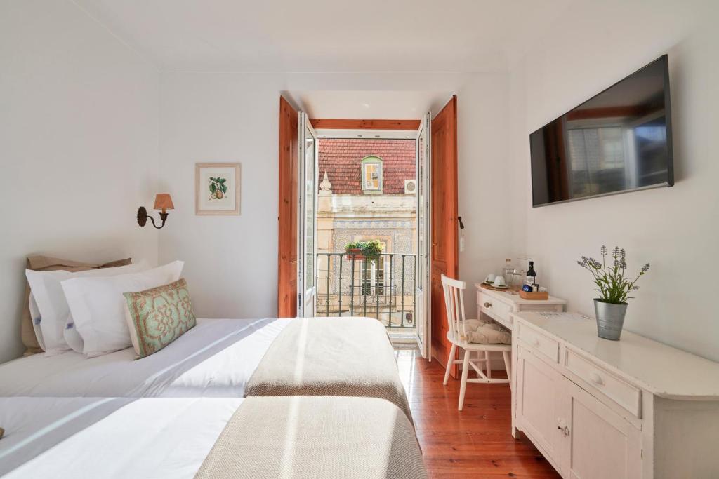 里斯本Casa do Mercado Lisboa的一间卧室配有一张床、一张书桌和一个窗户。