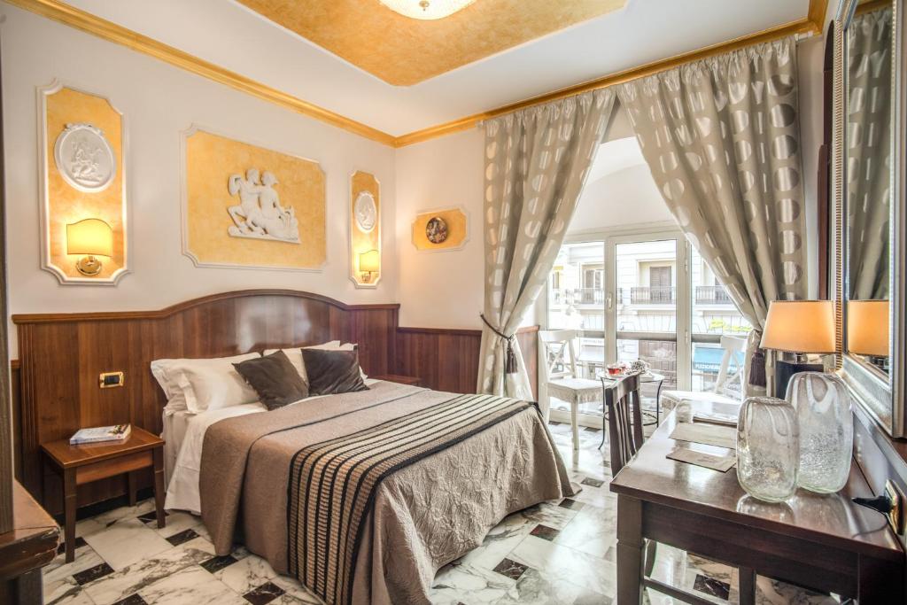 罗马纳齐萨旅馆的一间卧室配有一张床、一张桌子和一个窗户。