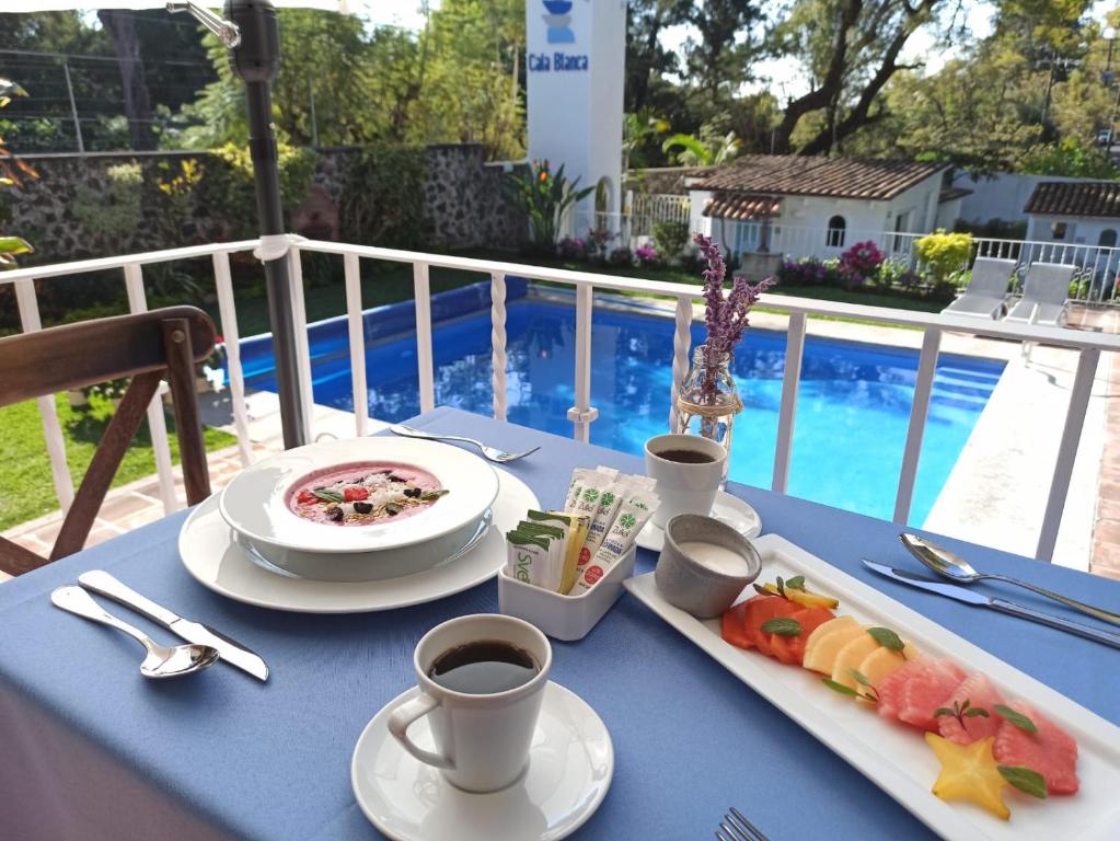 库埃纳瓦卡Hotel Cala Blanca Cuernavaca的一张蓝色的桌子,上面放着食物和咖啡