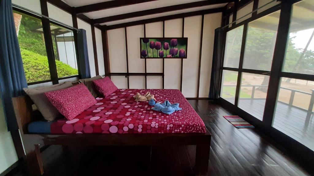 爱妮岛Duli Beach Resort的一间房间,里面摆放着红色的桌子和鲜花