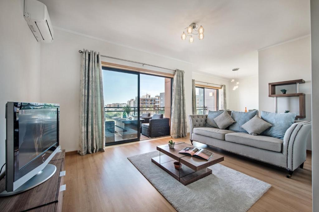 奥良Sunset Home Olhão- Modern 3 bed Luxury Apartment with rooftop pool的带沙发和电视的客厅
