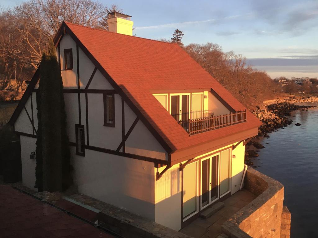 格洛斯特Point Radio Cottage的水体上带有红色屋顶的房子
