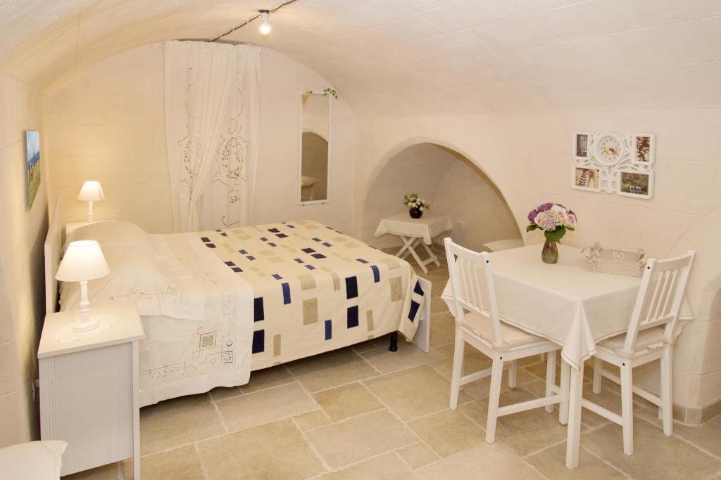 莫诺波利Locazione turistica Casa Liù的白色卧室配有床和桌椅
